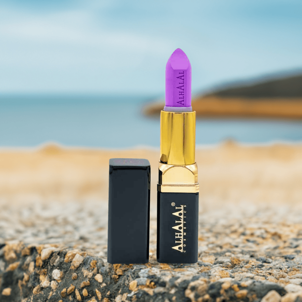 ROUGE À LÈVRES ALHALAL COSMETICS PARSE en velours violet avec support doré sur fond rocheux
